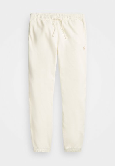 Calças de jogging brancas feitas de um tecido suave, com uma cintura elástica e cordão ajustável, além de punhos canelados. Logótipo discreto perto do quadril.