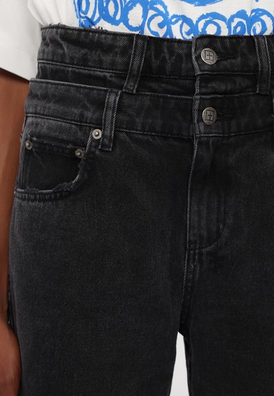 Jeans in denim nero con doppia vita e due bottoni metallici, dettagli delle tasche frontali e orli strappati in vita.