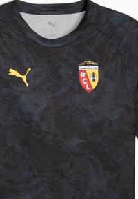 Camiseta deportiva negra con un patrón de camuflaje. Presenta un logo de Puma amarillo y el escudo del Racing Club de Lens en rojo, amarillo y negro.