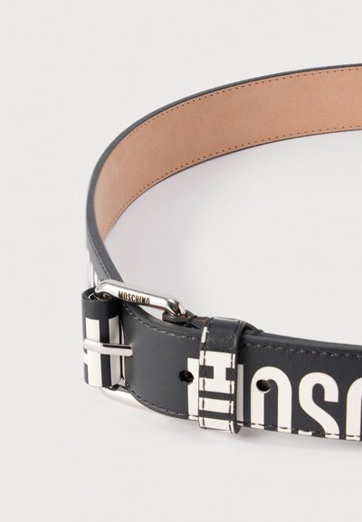 Μαύρη δερμάτινη ζώνη με μεγάλα λευκά γράμματα, ασημένια πόρπη με χαραγμένο το "Moschino" και ανοιχτό καφέ εσωτερική επένδυση.