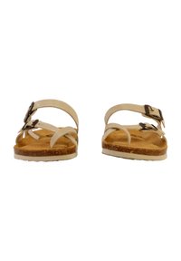 Helle beige Sandalen mit überkreuzten Riemen und verstellbaren Schnallen, Korkfußbett, flacher Sohle und glatter Textur. Minimalistisches Design.