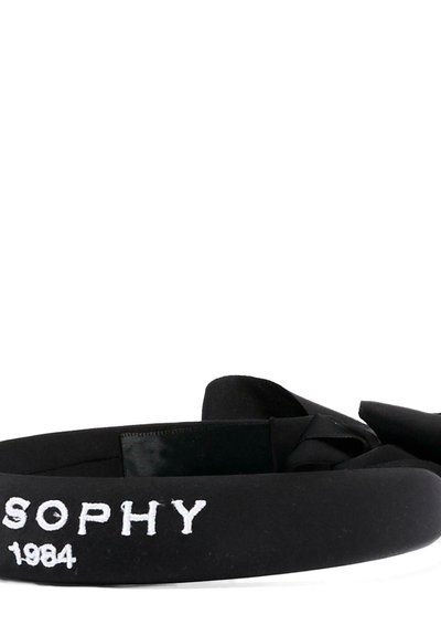 Fascia per capelli in tessuto nero con dettaglio a nodo, ricamata con testo bianco "SOPHY 1984" sul lato.