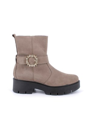 Stivale alla caviglia in suede taupe con punta arrotondata, tacco a blocco, cinturino decorativo con fibbia metallica circolare e dettagli testurizzati.