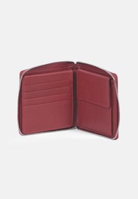 Portafoglio in pelle rossa con design a zip tutto intorno, dotato di più scomparti per carte e una tasca più grande per banconote o ricevute. Texture liscia in tutto.