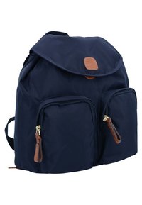 Zaino blu navy con forma arrotondata, dotato di due tasche anteriori con cerniera, un flap pieghevole e dettagli in pelle marrone.