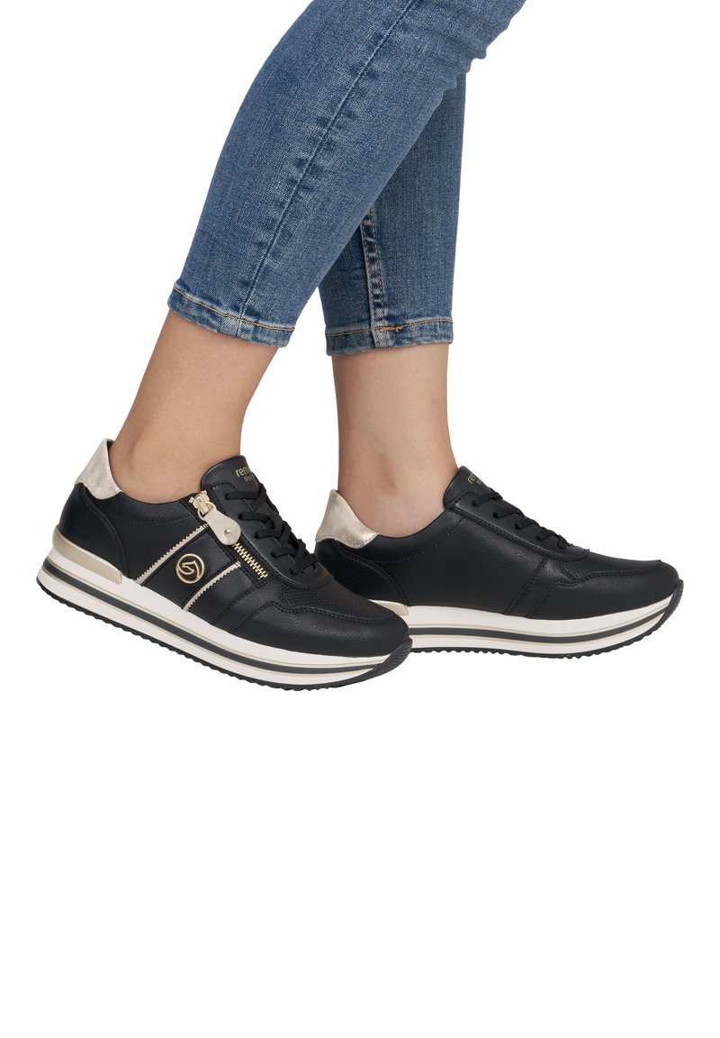 Schwarze Ledersneaker mit goldenen Akzenten, weißer Sohle und einem Reißverschlussdetail. Enthält schwarze Schnürsenkel und eine hellfarbige Fersenschlaufe.