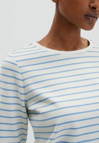 Gestreiftes Langarmshirt aus einem weichen, leichten Material. Die Farben beinhalten Creme und Hellblau. Rundhalsausschnitt, entspannte Passform.