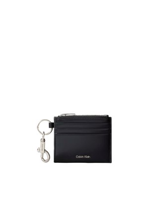 Porte-cartes Calvin Klein noir avec pochette zippée, quatre emplacements pour cartes et porte-clés argenté avec mousqueton attaché.