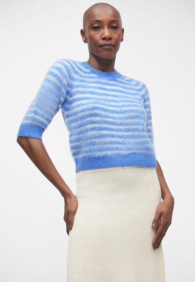 Pull court à manches courtes rayé bleu en tissu pelucheux ; présente des rayures horizontales bleu clair et blanches, un col côtes et un design cropped.