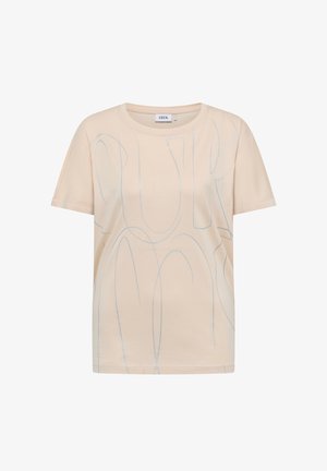 Maglietta beige a maniche corte con motivi astratti di linee azzurro chiaro e scollo rotondo, con etichetta "CECIL" all'interno del collo.