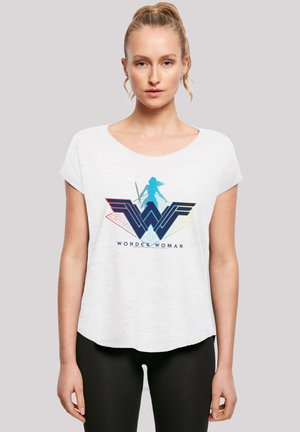 Hvit t-skjorte med korte ermer som har et fargerikt Wonder Woman-motiv med en blå silhuett og geometriske detaljer. Mykt stoff, avslappet passform.