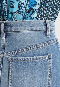 Jeans azzurri a vita alta con una finitura in denim testurizzata, dotati di una tasca sul retro e cuciture pulite lungo le cuciture.