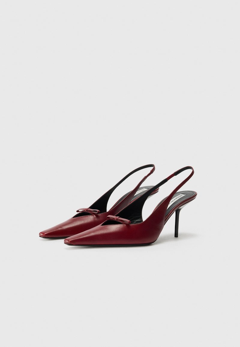 Röda läder slingback-klackar med spetsig tå, dekorativ båtdetalj och smal stilettklack. Svart inre foder. Sofistikerad design.