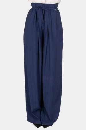 Pantaloni blu navy a gamba larga con vita alta arricciata e cintura annodata, indossati con scarpe nere appuntite.