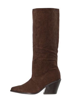 Botte haute jusqu'au genou en daim marron avec bout pointu et talon bloc en bois empilé incliné.