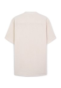 Camicia beige a maniche corte realizzata in tessuto testurizzato. Presenta un collo a giro e un dettaglio sul retro, che offre una vestibilità rilassata.