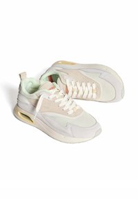 Sneakers in licht beige en wit, met mesh en suede materialen, ronde neus, vetersluiting, gevoerde kraag en zichtbare luchtkussens.