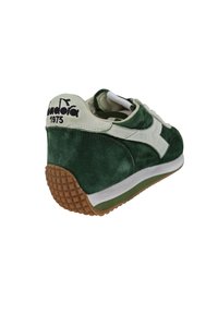 Sneaker verde in suede con accenti in pelle bianca, suola in gomma marrone testurizzata e branding sul tallone. Presenta un colletto imbottito per il comfort.