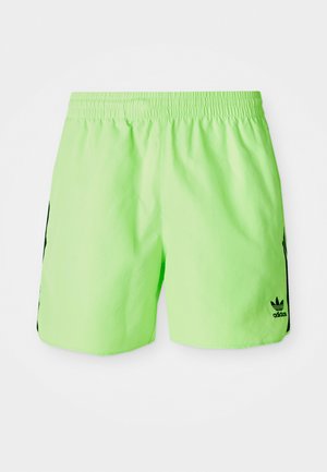 Neon green athletic shorts with an elastic waistband and black side accents. Features a small black logo on the lower right side.