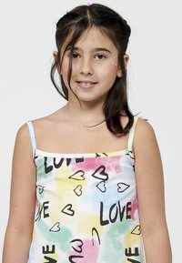 Bijela majica bez rukava s pastelnim vodenim uzorkom i crnim natpisom "LOVE" te uzorcima srca. Glatka, lagana tkanina.