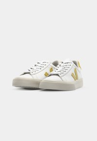 Vita lädersneakers i vitt med en texturerad beige gummisula. Har en gul V-logotyp och detaljer på hälen, rund tå och snörning fram.