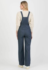 Ogrodniczki z denimu z dopasowaną górą, szerokimi nogawkami i regulowanymi ramiączkami. Ciemnoniebieski kolor z delikatnym efektem prania oraz elastycznym szczegółem z tyłu.