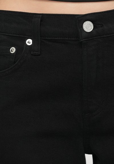 Čierne rifľové nohavice s vysokým pásom, zapínaním na strieborný gombík, pútkami na opasok a predným vreckom. Tkanina má hladký, textúrovaný povrch.