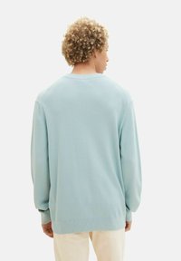 Sweatshirt a maglia waffle blu chiaro con maniche raglan e polsini a coste, caratterizzato da una vestibilità rilassata e un design semplice.