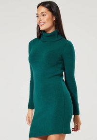 Turquoise turtleneck dress made of textured knitted fabric, featuring long sleeves and a fitted silhouette, with a hemline above the knee.