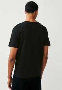 Next LICENSE REGULAR - Nyomott mintás póló - black run dmc