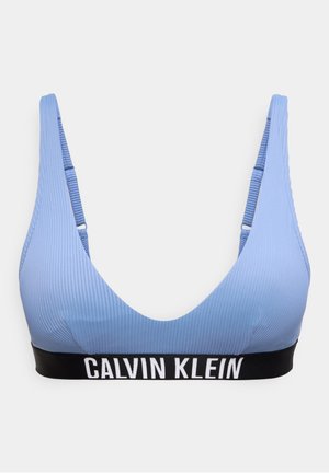 Lichtblauwe geribbelde sportbeha met verstelbare bandjes en een zwarte elastische band met de tekst "Calvin Klein" in het wit.
