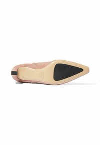 Zapato de tacón de ante rosa con punta afilada y suela de goma negra, con forro interior beige y sin acentos ni patrones visibles.