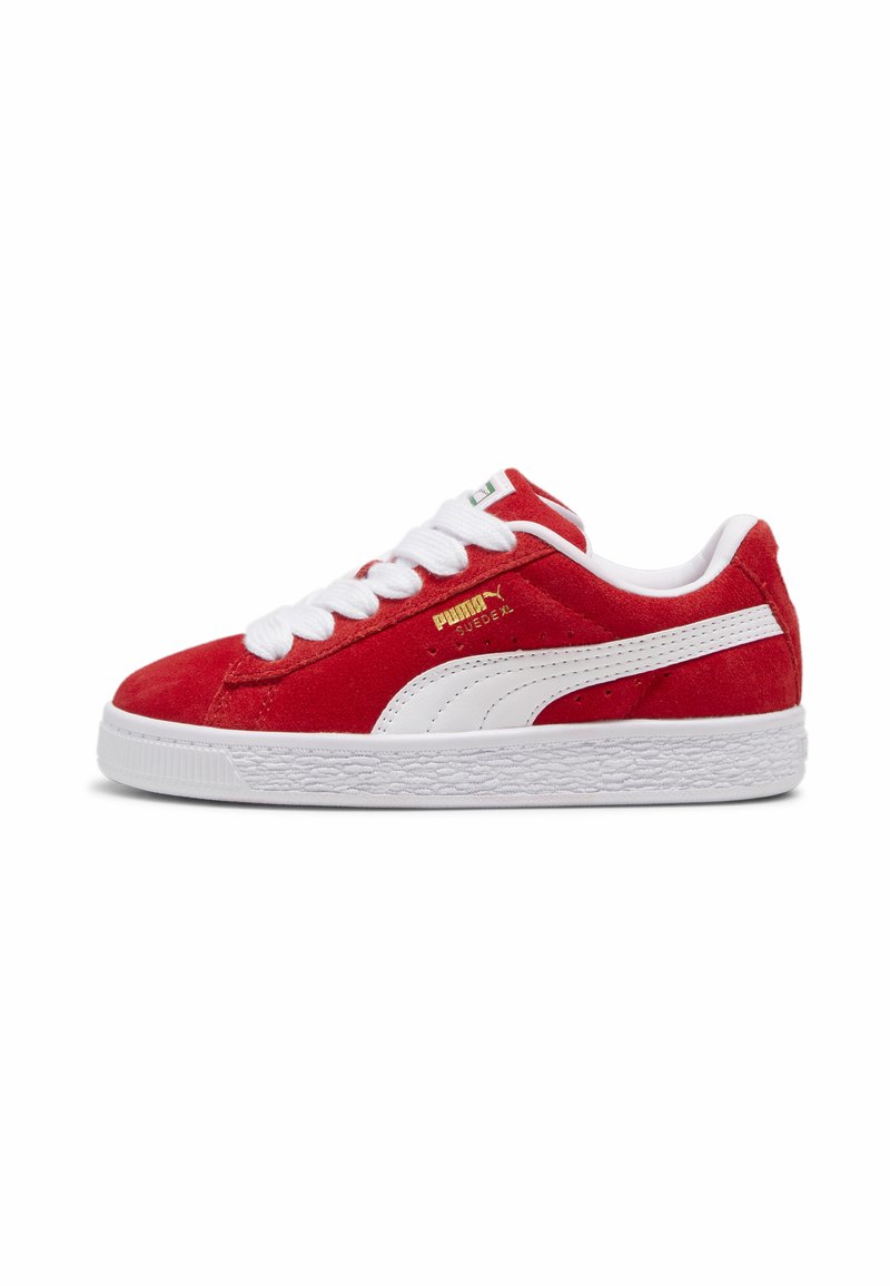 Röd mocka sneakers med vita detaljer, rund tå och snörning framtill. Har en strukturerad vit sula med ett subtilt mönster och signaturvarumärke.