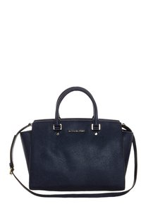 Borsa a mano in pelle blu navy con forma strutturata, doppio manico superiore, tracolla rimovibile e hardware in tonalità oro. Presenta dettagli con logo.