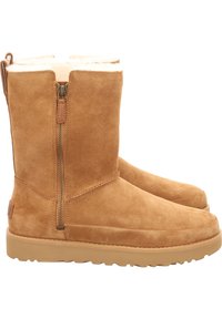 Bottes mi-mollet en daim couleur beige avec fermeture éclair latérale et doublure en laine, semelle en caoutchouc plate et languette au talon pour un enfilage facile.
