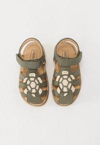 Grønne skinnsandaler med tort design foran, åpen tå-stil med borrelåsrem og sydd detaljer.