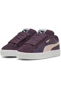Ljubičaste nubuk teniske sa teksturiranim sivim detaljima, bijelim gumiranim potplatom i ravnim vezicama. Puma logo na jeziku i sa strane. Niska dizajn.