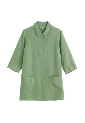 Vihreä polvipituinen mekko, jossa on kolme neljäsosaa hihaa, kaulus, napillinen etulista ja kaksi etutaskua valkoisella taustalla.