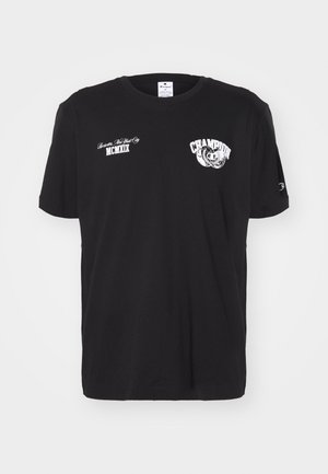 Camiseta de algodón negra con mangas cortas, cuello redondo, que presenta el logotipo y textos en blanco de "Champion" impresos en la parte frontal y en la manga.