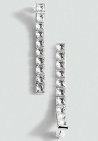 Orecchini in argento caratterizzati da un design lineare con cristalli rettangolari e sfaccettati fissati in fila, evidenziando le loro qualità chiare e riflettenti.
