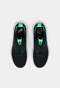 Scarpe sportive nere con accenti verdi, dotate di una tomaia traspirante, lacci e suola imbottita. Logo ben visibile sulla linguetta.