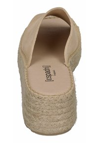 Beige espadrille shoe with a closed back, natural jute rope sole, and smooth upper material. Features minimal stitching detail on edges.