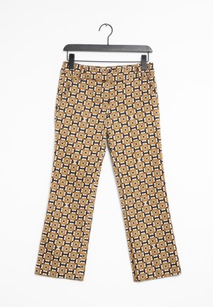 Pantalons avec un motif géométrique dans des couleurs marron, noir et crème. Le matériau semble tissé avec une texture lisse. Design évasé.