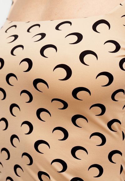 Γυμνό τοπ χωρίς μανίκια με επαναλαμβανόμενο μοτίβο μαύρου ημισεληνοειδούς, κατασκευασμένο από απαλό ύφασμα με εφαρμοστό σχέδιο και τετράγωνο ντεκολτέ.