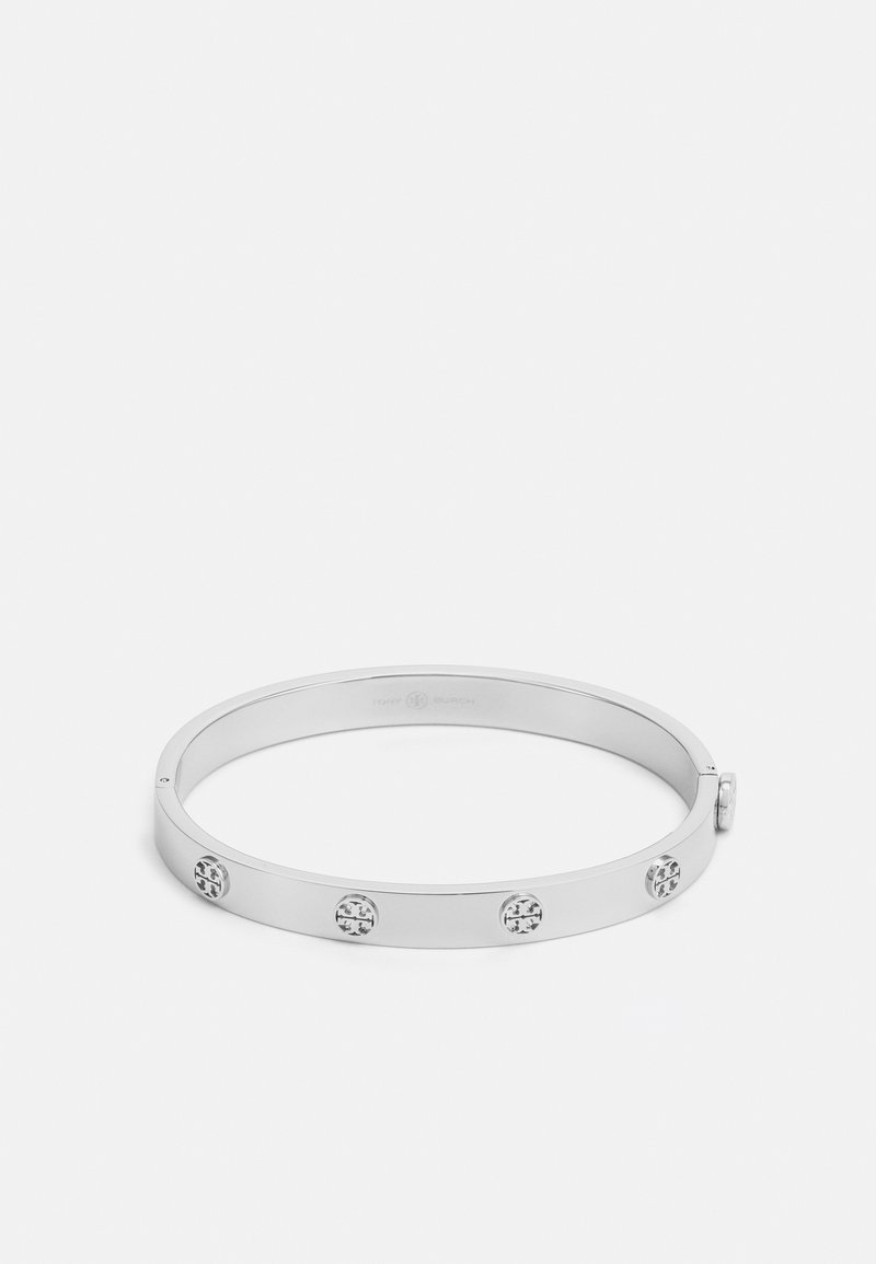Silver metal bangle bracelet with a smooth, rounded shape featuring five circular embellishments. Minimalist design with a polished finish.
