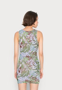 Vestuário sem mangas com um padrão botânico multicolorido, apresentando folhas verdes e flores castanhas sobre um fundo azul claro.