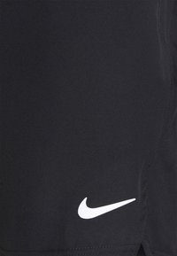 Bermudas deportivas negras de tela ligera con un logo blanco de Nike en la parte inferior. Textura suave, diseño simple.