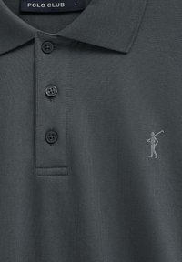 Polo gris foncé avec trois boutons, un col et une petite figure brodée d'une personne tenant un club de golf sur la poitrine.