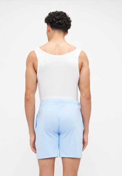 Camisola branca sem mangas e calções azul claro com um cós elástico, vistos de trás. Textura de tecido suave, sem padrões ou detalhes.