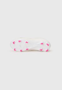 Botín de fútbol con una parte superior blanca y suela transparente. Presenta tachuelas de acento rosa y un detalle texturizado en la suela para tracción.